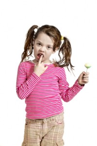 Close-up of adorable little girl with a lollipop, isolated on white background